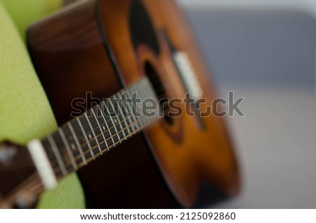 Selective focus guitar fretboard with strings on blurred gray background with copy space. Music concept. Guitar neck texture. Gray fabric surface. The creative process. Royalty-Free Stock Photo #2125092860