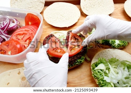 
The chef prepares a burger in a restaurant.