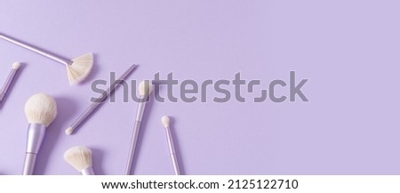 Makeup brushes banner. Set of glamour makeup brushes on pastel violet background. Magazines, social media. Visagist tools. Top view, copy space. Creative flat lay. Cosmetics products web line, sale