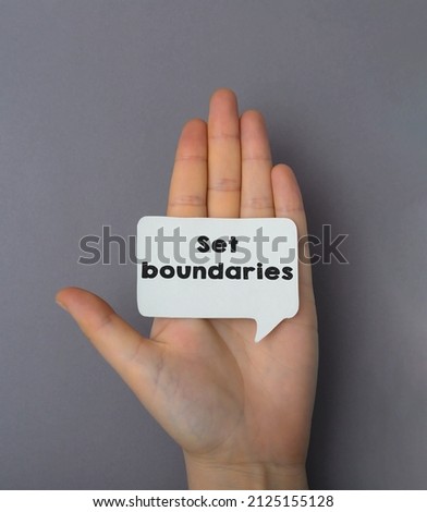 Close-up girl hand holding card with text, set boundaries, image business concept on gray background Royalty-Free Stock Photo #2125155128
