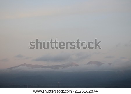Picture of a mountain landscape covered in clouds in the morning when the sun has not fully risen