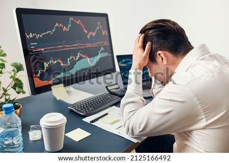 Worried businessman looking at charts stressed by news from stock market. Investor lost money online. Man analyses loss and profit. Businessman investing stocks online. Man working with stock charts Royalty-Free Stock Photo #2125166492