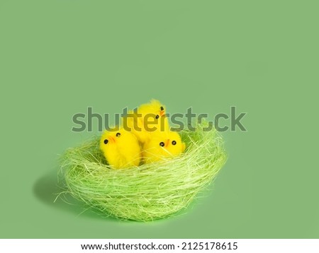 Тoy chickens in a green nest .delicate green background
