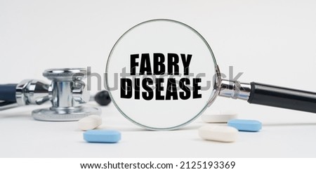 Medicine and health concept. On a white surface lie pills, a stethoscope and a magnifying glass with the inscription - FABRY DISEASE Royalty-Free Stock Photo #2125193369
