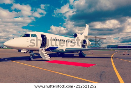 White reactive private jet, the front landing gear and a ladder on blue sky and clouds Royalty-Free Stock Photo #212521252