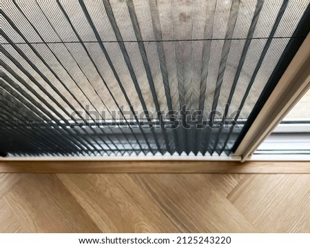 Selective focus mosquito net wire screen on door near wooden floor. Royalty-Free Stock Photo #2125243220