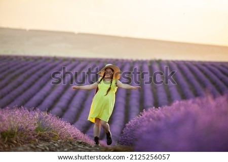 pregnant Woman in lavender flowers field at sunset in yellow dress.