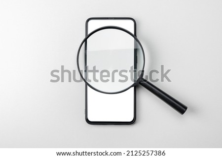 Mockup cellphone with magnifying glass. Magnifying glass search app network, smartphone blank screen template. Search and exploration concept with black magnifying glass and modern cell phone