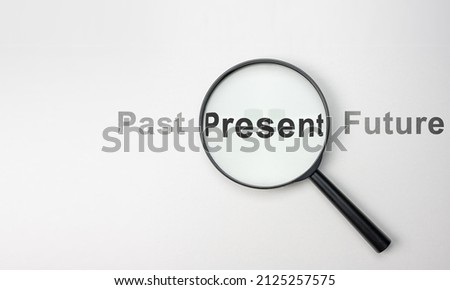 Present wording inside of Magnifier glass on white background for focus current situation, positive thinking mindset concept. present in focus. wide, top view Royalty-Free Stock Photo #2125257575