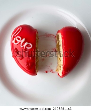 Cake, cupcake, dessert red heart with inscription love isolated on white background. Cut in half. Heartbreak concept Royalty-Free Stock Photo #2125261163