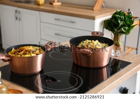 Cookware with prepared food on stove in kitchen Royalty-Free Stock Photo #2125286921