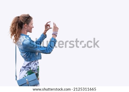 Young tourist woman photographing by smartphone, isolated on white, empty space