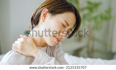 Asian woman with shoulder pain Royalty-Free Stock Photo #2125335707