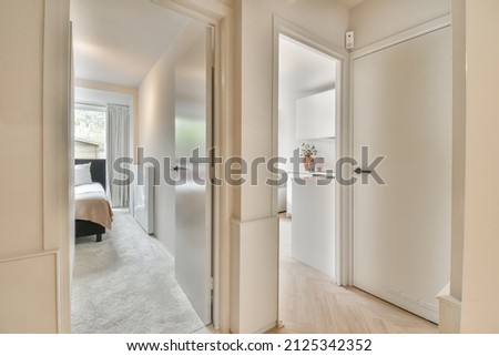 corridor with two opened doors leading to the bedroom and kitchen room Royalty-Free Stock Photo #2125342352