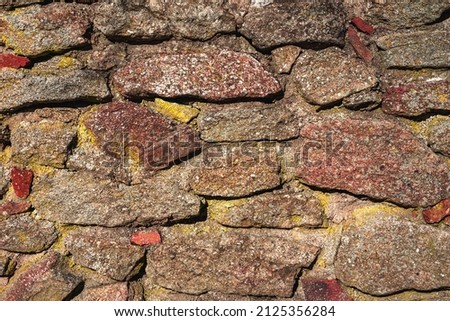 Old stone wall, structure. old broken stones, cement joints close-up. crumble with age. construction, repair. concept of destruction, decline. High quality photo