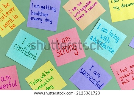 Positive affirmations concept. Phrases of different colors sheets for notes on a green background. Motivational concept with handwritten text. Royalty-Free Stock Photo #2125361723