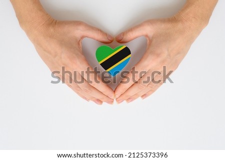 The national flag of Tanzania in female hands.