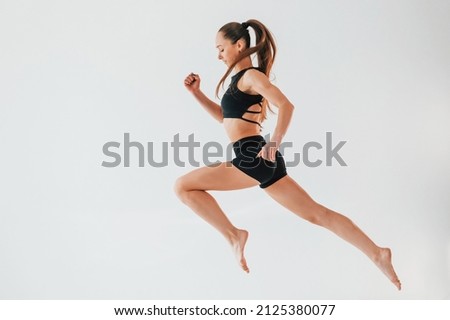 Flexibility of the body. Young woman in sportive clothes doing gymnastics indoors.