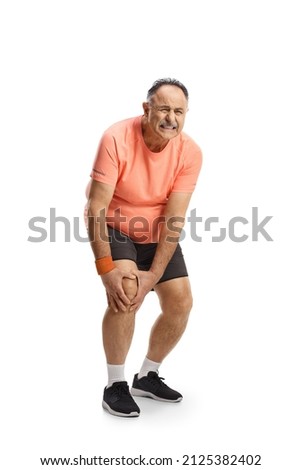 Full length portrait of a mature man in sportswear holding his painful knee isolated on white background Royalty-Free Stock Photo #2125382402