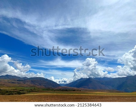 Mountains and clouds. Amazing cloudscape in sky over fields and mountains of Peru, South America. Impressive clouds. Majestic landscape of Andes mountains. 