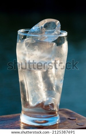 ice cubes in glass being dissolved by the heat of the air
