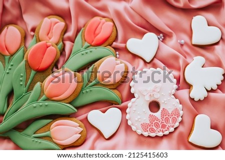 background banner greeting card for international women day with eight number, tulips and pigeon shape gingerbread cookies on pink silk fabric background
