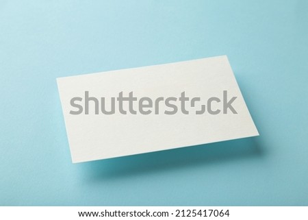 Blank white business cards on blue paper background. Mockup for branding identity. Template for graphic designers portfolios.