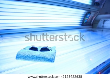 Towel and protective goggles on sunbed Royalty-Free Stock Photo #2125422638