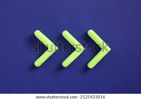 Green arrows pointing right side. Three dimensional arrow sign showing direction on blue background. Development  concept, go green or heading target metaphor, striving for the goal, going forward. Royalty-Free Stock Photo #2125423016