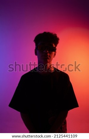 Portrait of a young guy. Male silhouette on a multicolored background. Purple background. Desktop wallpapers. A man in motion.