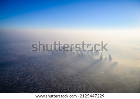 Doha skyline at sunrise with morning fog Royalty-Free Stock Photo #2125447229