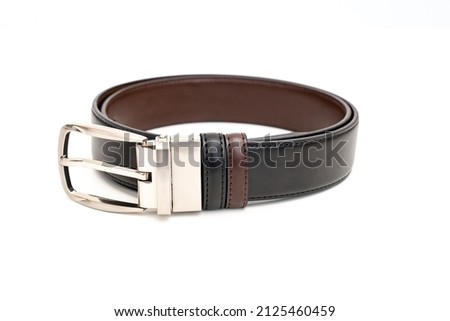 Double-sided black and brown leather belt with an unbuttoned buckle on a white background.