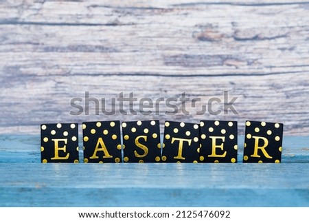 word Easter in gold on wooden background