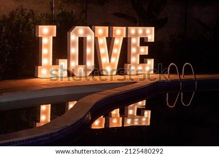 Love 3d illustration. big white love letters in light bulbs for photo booth at wedding reception in night outdoors. love word lights, stylish evening decor for wedding ceremony
