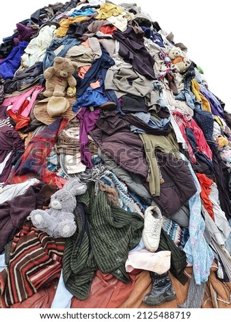 large pile stack of textile fabric clothes and shoes. concept of recycling, up cycling, awareness to global climate change, fashion industry pollution, sustainability, reuse of garment Royalty-Free Stock Photo #2125488719