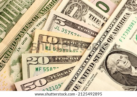 USA dollar bills. Texture of multiple US dollar banknotes. Background from paper money. A few dollars of varying nominal values. Close-up of multiple American dollar greenbacks. Royalty-Free Stock Photo #2125492895