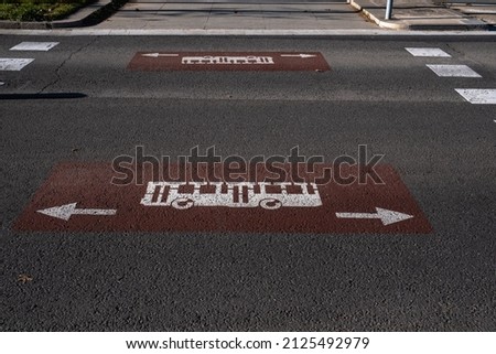 Concrete road closeup with bus stop sign drawn. Arrows showing the direction. Road sign. Concrete, asphalt.