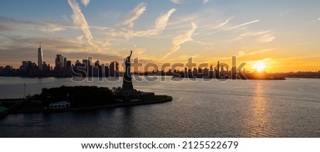 The Statue of Liberty and New York City at sunrise.