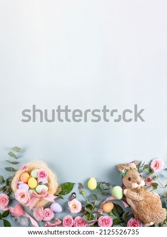Happy Easter concept with easter eggs, bunny and spring pink flowers. Vertical Easter banner with copy space for text. Flat lay.