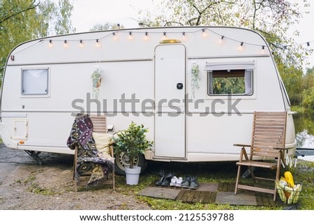 Family traveling in camper,house on wheels,trailer,motor home. Romantic road travel,freedom life.Campsite overnight, parking in van.Wanderlust vacation,weekend. Happy adventure.Relax area with chairs. Royalty-Free Stock Photo #2125539788