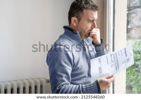 One man worried about bills reading energy increase costs Royalty-Free Stock Photo #2125548260