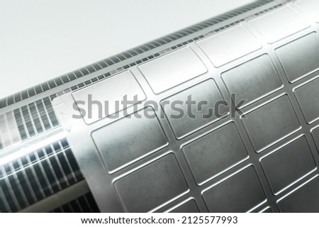 Used magnetic cylinder with attached flexible die for die cutting on rotary printing press. Die-cutting of labels. Cut knife for paper labels. Rotary stamp. Offset cutting knife for printing machine Royalty-Free Stock Photo #2125577993