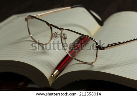 Eye glasses lying on opened blank notepad