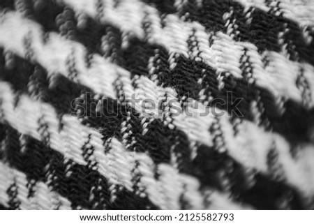 Woolen fabric in black and white check with a Pepita pattern. Macrophoto.