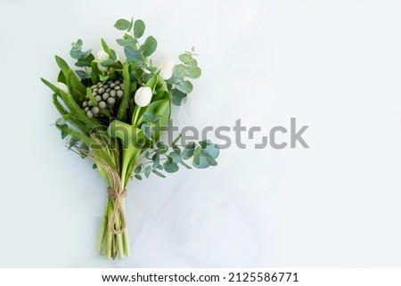 bouquet of green color with a white tulip lies on a white background