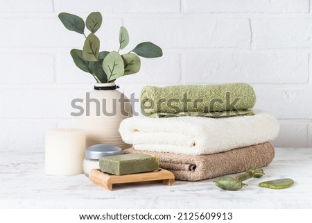 Spa composition in white bathroom with towels and cosmetics. Royalty-Free Stock Photo #2125609913