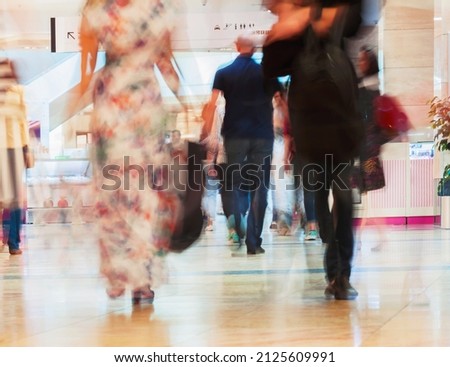 Abstract defocused motion blurred walking young men and women in the shopping center. For background , backdrop, substrate, composition use.