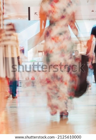 Abstract defocused motion blurred young people walking in the shopping center. Beautiful figure of a girl close-up. urban lifestyle concept. For background , backdrop, substrate, composition use.