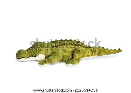 Doll of a green combed crocodile on a white background. Soft toy wildlife. Toy plush predator.