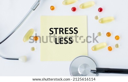 text LESS STRESS on a yellow card on a white background row stethoscope and scattered tablets